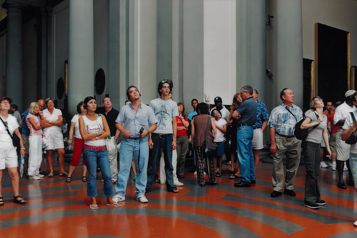 Color photograph of a group of people of different ages standing in a semicircle looking at something behind the camera | Thomas Struth | Audience 5, Florenz 2004, 2004 | The ALBERTINA Museum, Vienna – The ESSL Collection