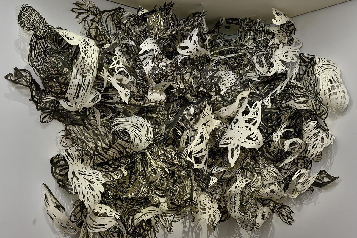 A corner of a room with a brown parquet floor and white wall. On the wall, in the corner, hangs a large installation of paper cut-outs in various patterns in black and white. Credit: Birgit Knoechl | out of control_revisited the autonomy of growth_0IV, 2006-2008/2012 | ALBERTINA, Wien – Erwerbung aus Mitteln der Galerienförderung des BMUKK 2012 © Birgit Knoechl / Foto: ALBERTINA, Wien