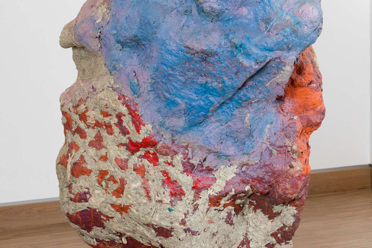 Sculpture in the form of a large stone standing on wooden boards and painted in shades of red and blue. Credit: Franz West | Sisyphos, 2002 | The ALBERTINA Museum, Vienna – The ESSL Collection © Archiv Franz West © Estate Franz West, Photo: Lisa Rastl
