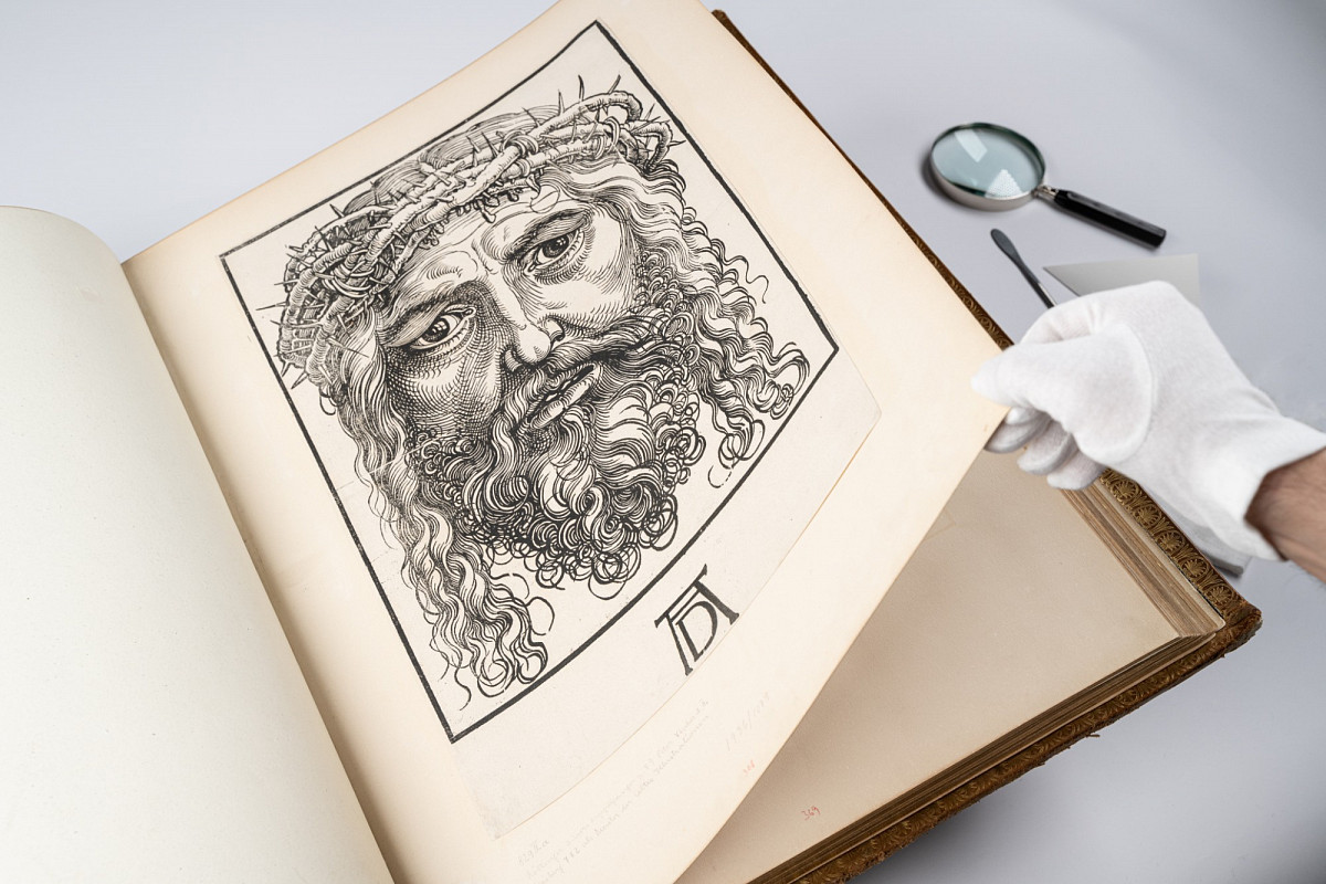 Close-up of a historical anthology with a picture of the thorn-crowned head of Christ by Sebald Beham.