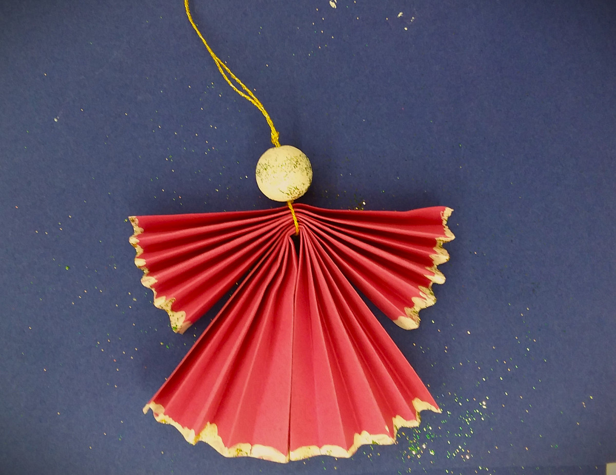 Ein Engel aus gefaltetem Papier in Gold und Rot