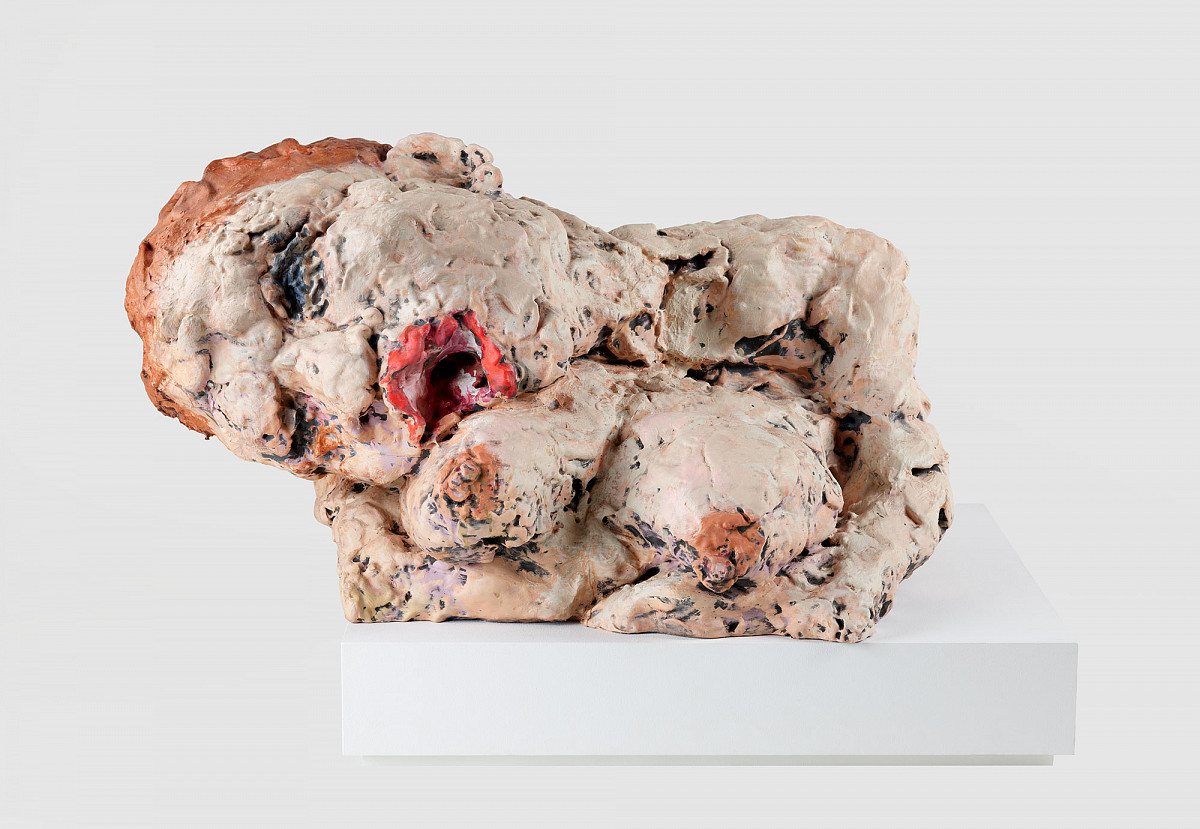 The head and upper body of a woman. The head is tilted to one side. Brownish-red hair, blue eyes, and a red, open mouth. Below, the breasts can be seen, each supported by the forearms.