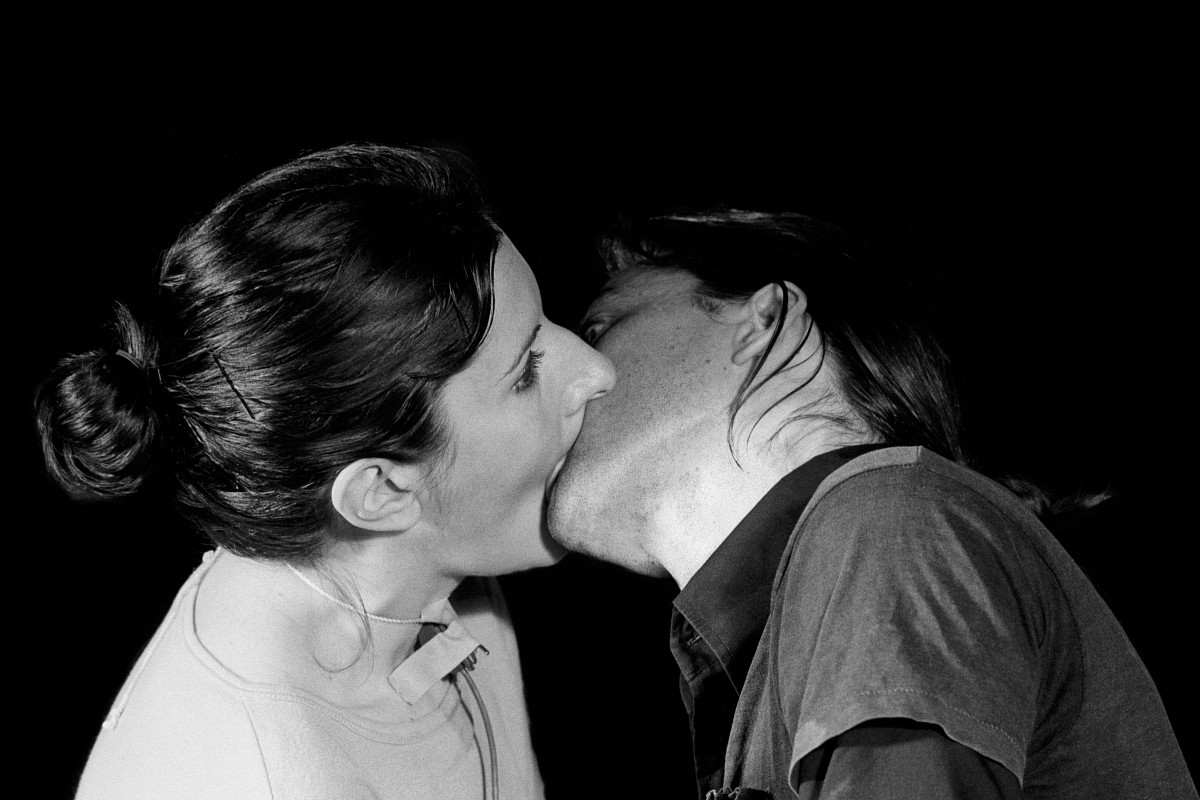 Marina Abramović and Ulay stand opposite each other, mouths pressed tightly together; they share a single breathing cycle.