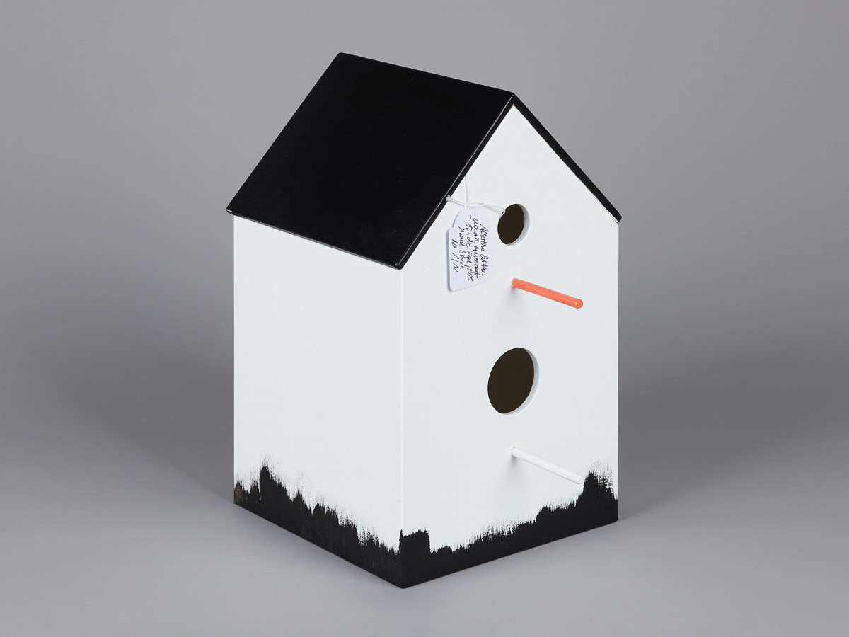 White birdhouse with black roof and black trim on the underside.