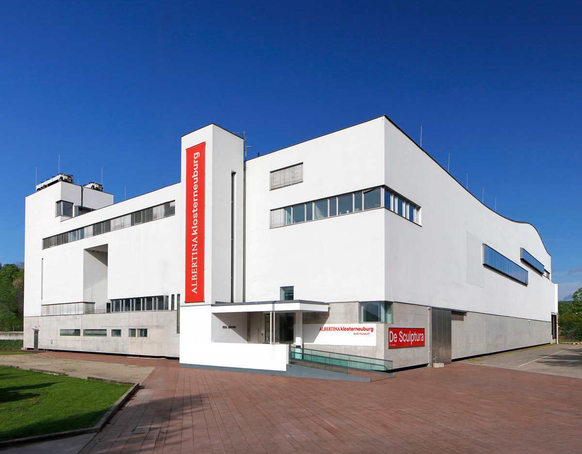 Foto eines modernen, weißen Gebäudes mit großem roten Schriftzug ALBERTINA KLOSTERNEUBURG.