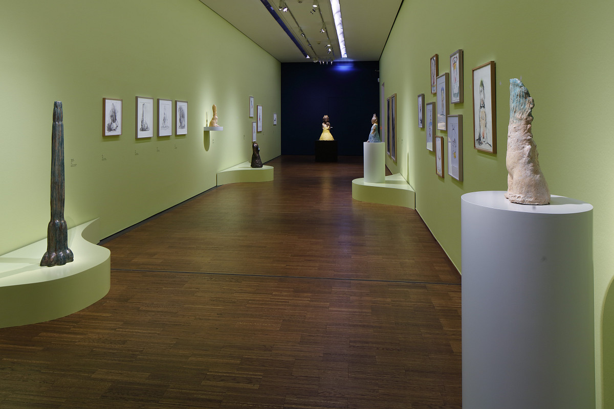 Exhibition view – several artworks on a green wall.