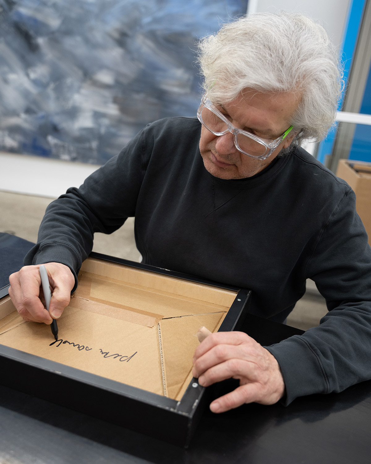 The artist signing the works.