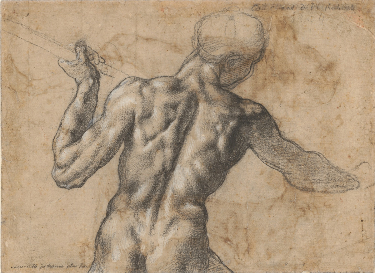 A view from behind of a naked man holding a spear.