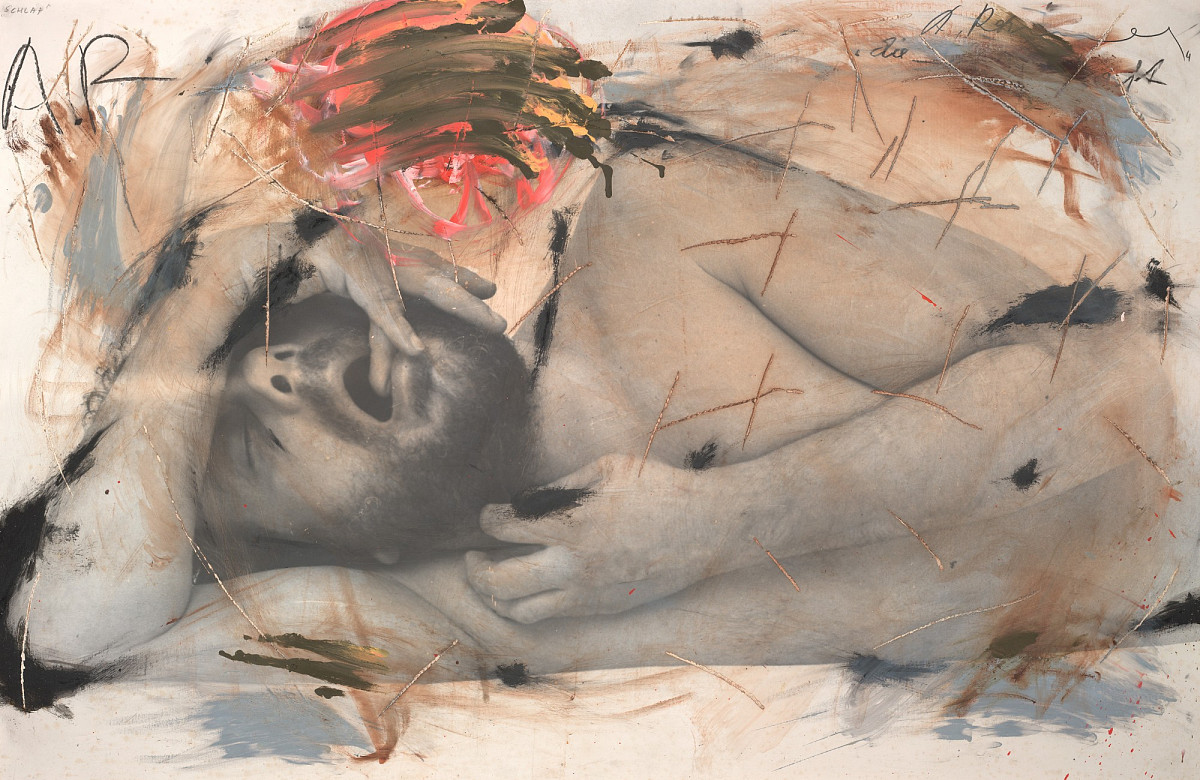 A man lying on his side asleep, with a finger in his mouth.
